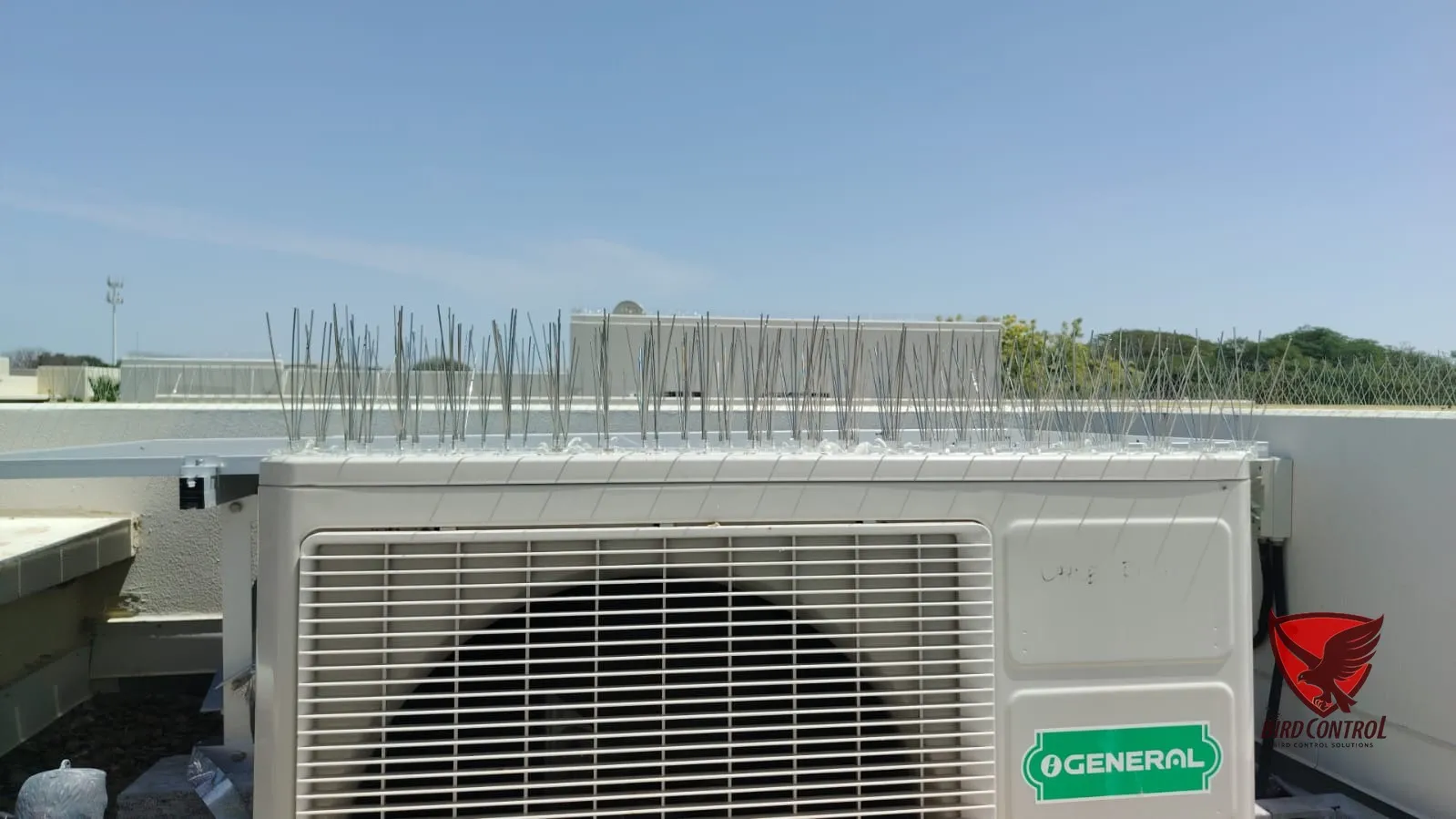 Bird spikes fitted on top of AC condenser unit to stop bird perching